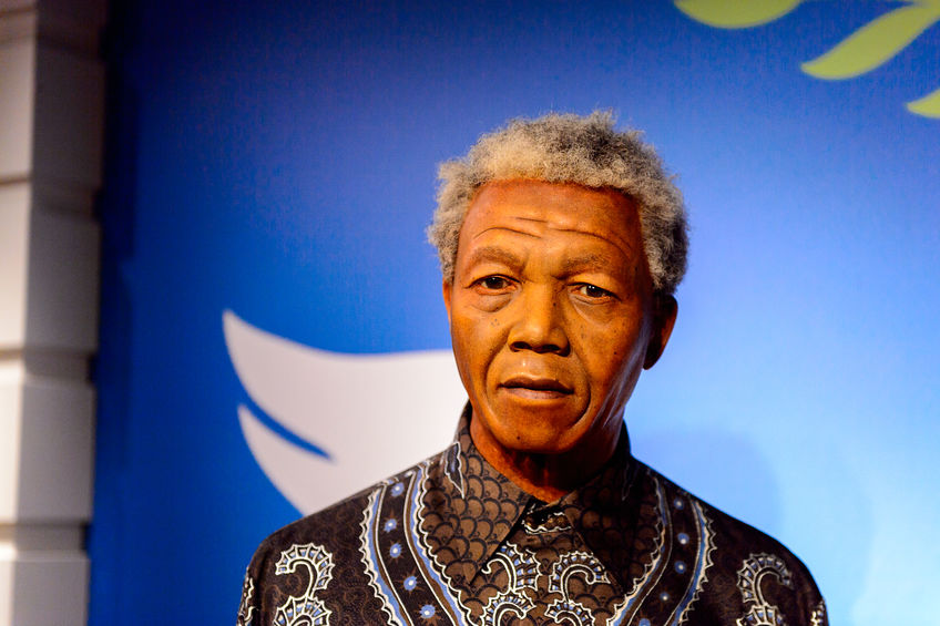 Nelson Mandela pictured in front of blue background.