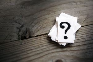 Questions on cards on a wood surface.