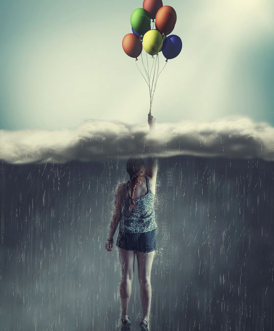 Woman flying with balloons through a rainy cloud to the sunny sky